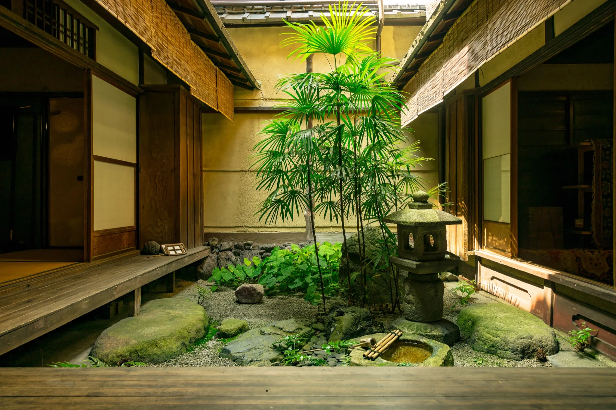 灯籠と苔むした石をしつらえた坪庭